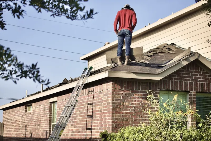 Professional roofer working on a residential roof in Harliss